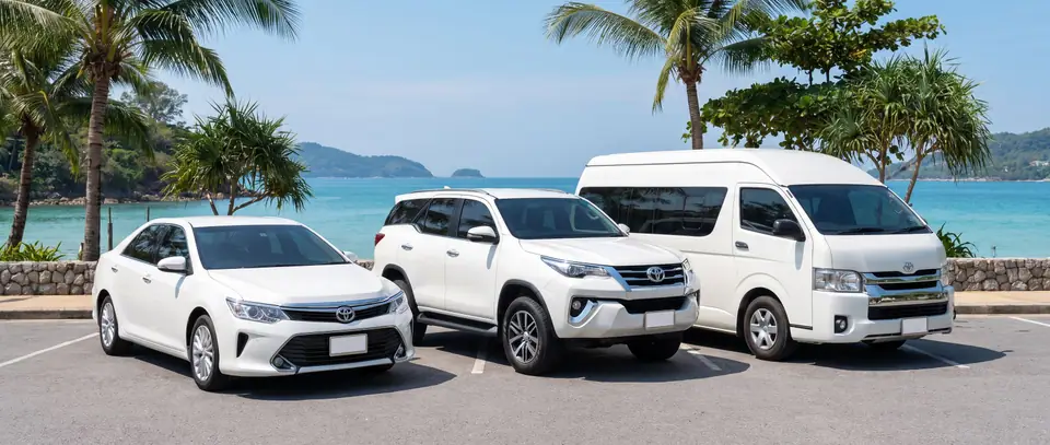 Sedan, SUV en minibus geparkeerd aan zee op Phuket